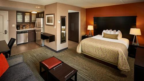 a hotel room with a bed and a kitchen at Staybridge Suites Hamilton - Downtown by IHG in Hamilton