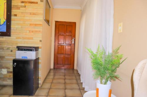 a hallway with a door and a plant in front of it at Masai Shuttles And Hotel in Polokwane