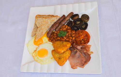 a plate of breakfast food with eggs sausage beans and toast at Masai Shuttles And Hotel in Polokwane