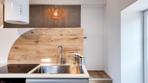 a kitchen with a sink and a wooden wall at El Sart in Sart-lez-Spa