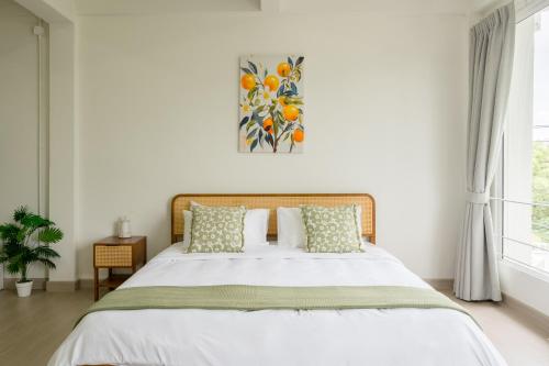a bedroom with a bed and a painting on the wall at Glow House Sukhumvit 54 in Bangkok