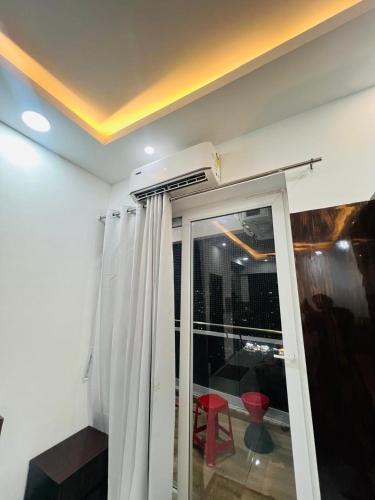 a room with a sliding glass door with a red chair at Bansal Studio in Noida