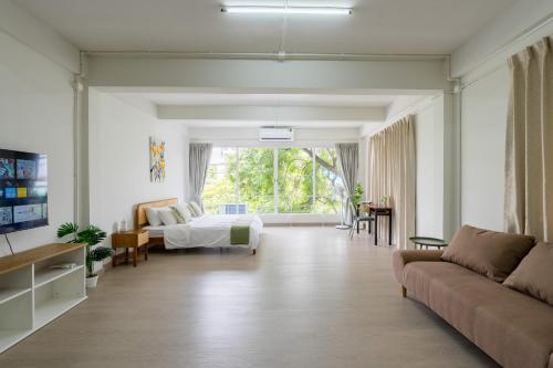 a living room with a bed and a couch at Glow House Sukhumvit 54, Spacious Modern Rooms near BTS On Nut in Bangkok