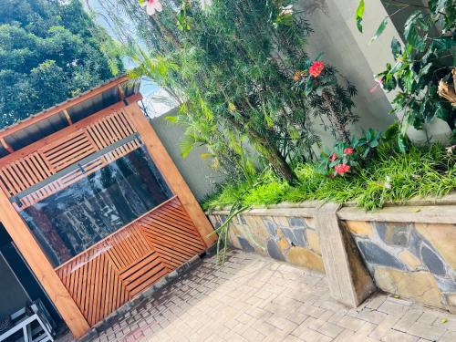 a wooden bench in front of a building with flowers at Sunset Inn Lodge in Arusha