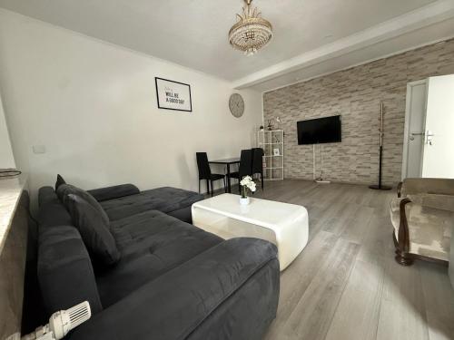 a living room with a couch and a table at Schöne 2 Zimmer Appartment mit Bad und Küche Self- Check-in in Mönchengladbach