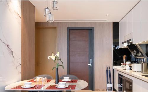 a kitchen with a table and chairs and a dining room at 来咖民宿酒店三亚海棠湾亚特兰蒂斯棠岸店 in Fengtang