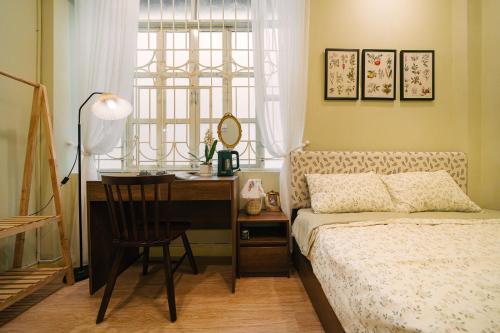 une chambre avec un bureau et un lit et un bureau et une chaise dans l'établissement Anchie Vintage Homestay - Train Street Hanoi, à Hanoï