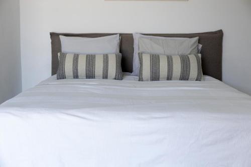 a large white bed with two pillows on it at Melita home in Mesochórion