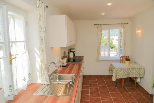 a kitchen with a sink and a counter with a table at Villa Leni - Premium Apartments in Bad Ischl