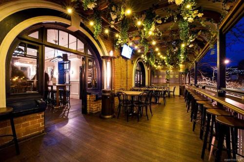 a restaurant with tables and chairs in a building at Frisco Hotel in Sydney