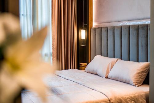 a bed with a pillow on it in a room at Amazing Apartment with Pool 1BR Near Bazaar in Chiang Mai