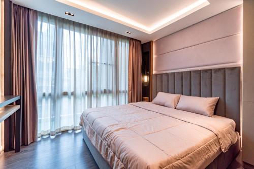 a bedroom with a large bed and a large window at Amazing Apartment with Pool 1BR Near Bazaar in Chiang Mai