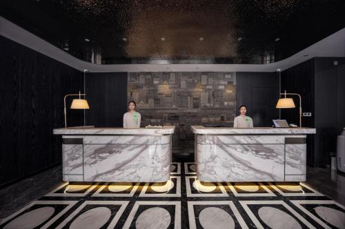 two people standing at a counter in a bathroom at Healing Mind Dianyu Yunjing International Resort Hotel Kunming Dianchi Grand View Park Fuhai Metro Station Branch in Kunming