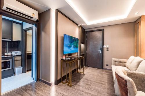 a living room with a couch and a television at Amazing Apartment with Pool 1BR Near Bazaar in Chiang Mai