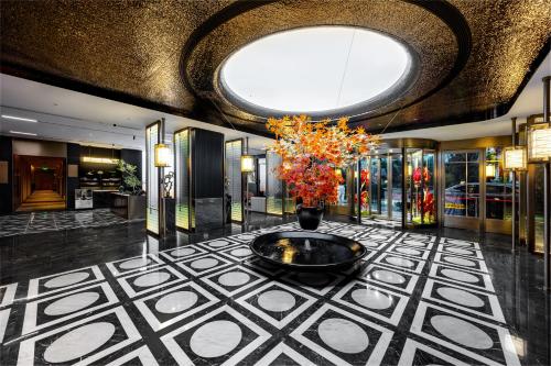 a lobby with a vase with a plant in it at Healing Mind Dianyu Yunjing International Resort Hotel Kunming Dianchi Grand View Park Fuhai Metro Station Branch in Kunming