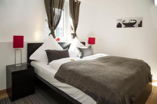 a bedroom with a bed with white sheets and pillows at Apart Hotel Paradies in Bad Salzschlirf