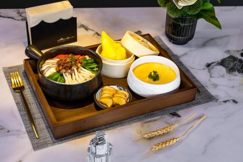 ein Tablett mit Essen mit einer Schüssel Suppe und anderen Lebensmitteln in der Unterkunft Healing Mind International Hotel Kunming Dianchi Grand View Park Fuhai Metro Station Branch in Kunming