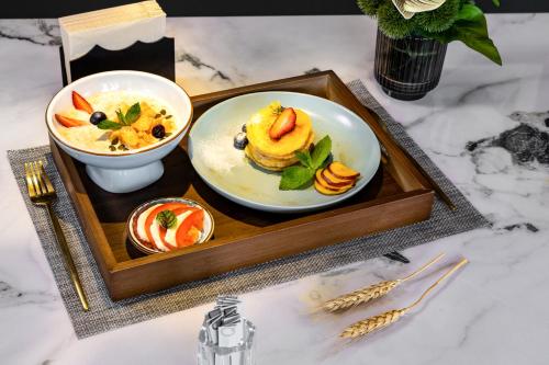 ein Tablett mit einem Teller Essen auf einem Tisch in der Unterkunft Healing Mind International Hotel Kunming Dianchi Grand View Park Fuhai Metro Station Branch in Kunming