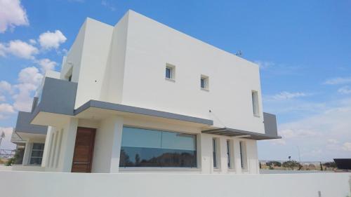 a white house with a large window at T&E Villa in Larnaca