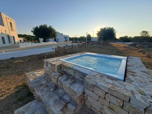 a swimming pool on a stone wall in a yard at La Casa di Gioia - Dimora Rurale in Trappeto