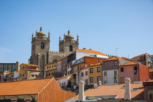 a large building with a clock on top of it at FLORES 36 by YoursPorto in Porto