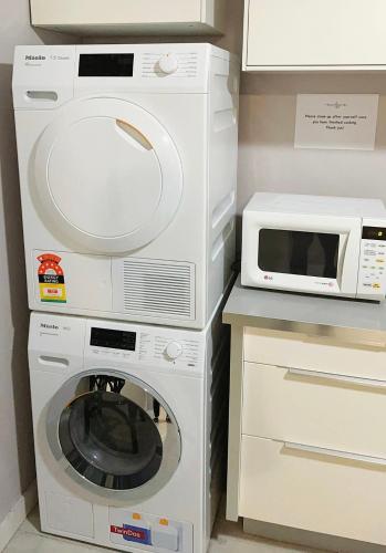 a white washer and dryer next to a microwave at Frisco Hotel in Sydney