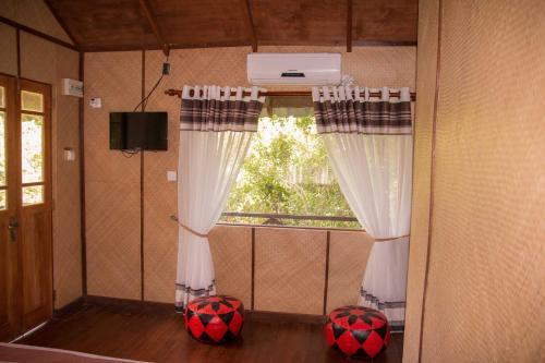 a room with two curtains and two balls in front of a window at The Thick Forest in Sigiriya