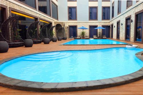 a large pool in the middle of a building at Swiss-Belinn Indramayu in Indramayu