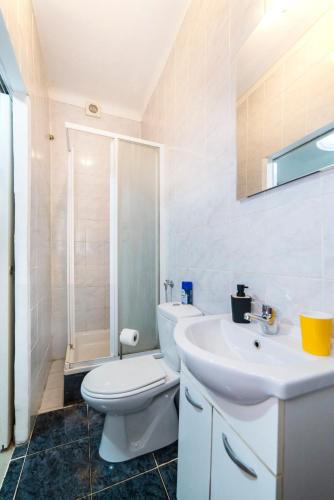 a white bathroom with a toilet and a sink at Apartment Senka in Zagreb