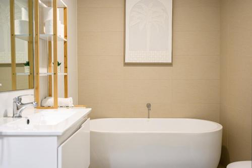 a bathroom with a white tub and a sink at Liverpool 3Br APT Business Hospital Parking 8ppl in Liverpool