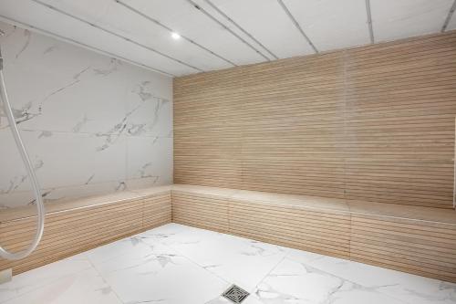 a bathroom with a shower and a white tile floor at Mr Neve Tsedek in Tel Aviv