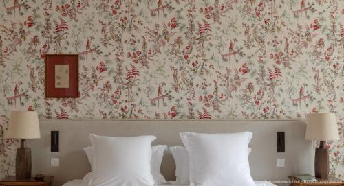 a bedroom with a wall with a floral wallpaper at Les Sources de Vougeot in Vougeot