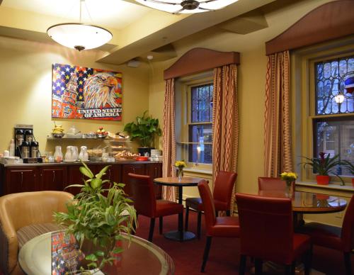 un restaurante con mesas, sillas y ventanas en Alexander Inn en Filadelfia
