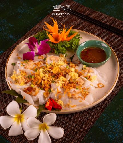a plate of food with flowers on a table at Harvest Day Hoi An in Hoi An