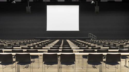an empty lecture hall with chairs and a white screen at Clarion Hotel Oslo Airport in Gardermoen