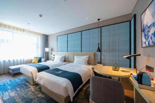 a hotel room with two beds and a table at Echarm Hotel Shenyang Nanta Shoe City Army General Hospital in Shenyang