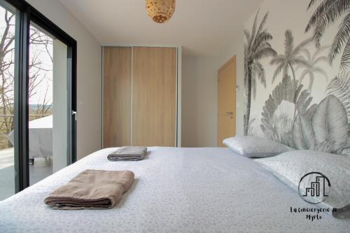 a bedroom with a large bed with towels on it at La Vigne in Albi