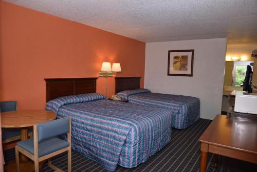 ein Hotelzimmer mit 2 Betten und einem Tisch in der Unterkunft Bonifay Inn in Bonifay