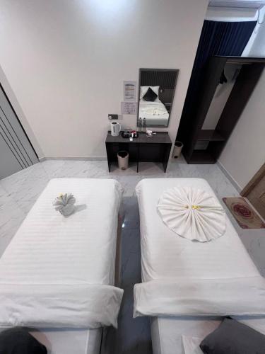 two white chairs in a room with a table at Fiya Inn in Maalhos