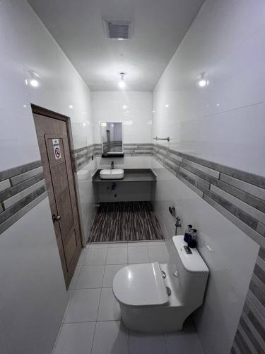a bathroom with a toilet and a sink at Fiya Inn in Maalhos