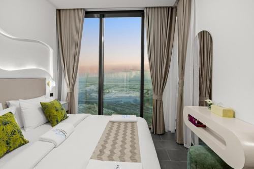 a hotel room with a white couch and a large window at Bright, Breezy and Central 1BR with Extra Room in Dubai
