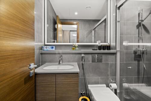 a bathroom with a sink and a mirror at Bright, Breezy and Central 1BR with Extra Room in Dubai