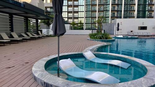a swimming pool with an umbrella in a building at Bright, Breezy and Central 1BR with Extra Room in Dubai