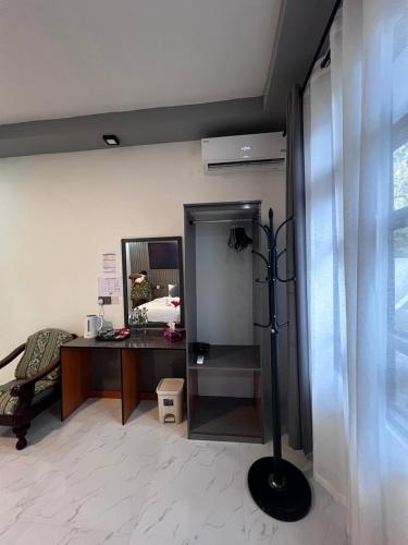 a room with a desk with a mirror and a lamp at Fiya Inn in Maalhos