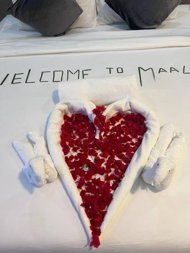a heart made out of red sequins on a bed at Fiya Inn in Maalhos