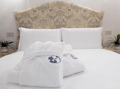 a white bed with white blankets and pillows at Hotel Colombina in Venice