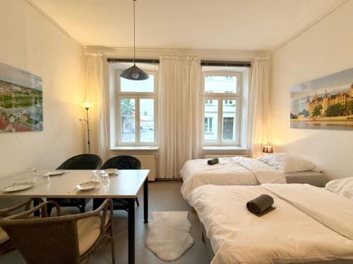 a room with three beds and a table and chairs at Berta - Zentrale Wohnung - 2 Küchenzeilen - Nähe Bahnhof in Schwerin