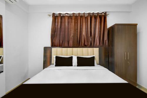 a bedroom with a large bed and a window at Super Townhouse Pimple Nilakh Pune in Dāpuri