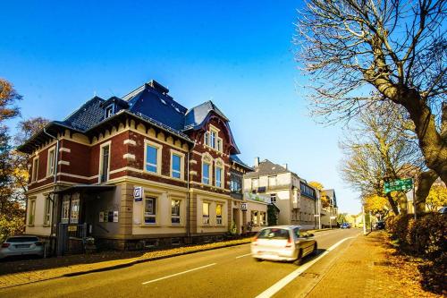 a car driving past a large house on a street at Urlaubsloft Augusts Schatzkiste in Marienberg