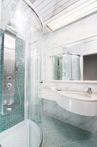 a bathroom with a glass shower and a sink at Hotel Majestic in Gabicce Mare